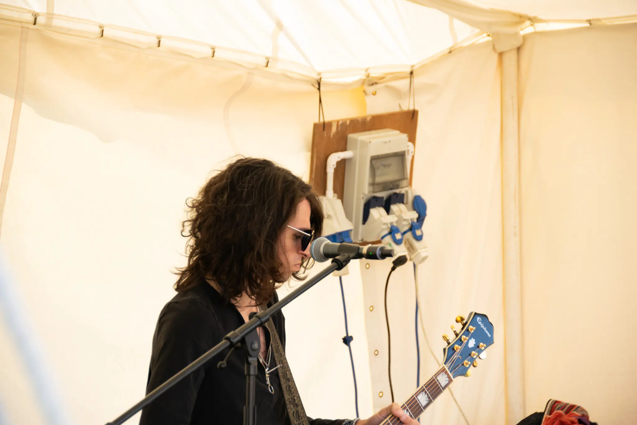 Guitarist performing under a tent