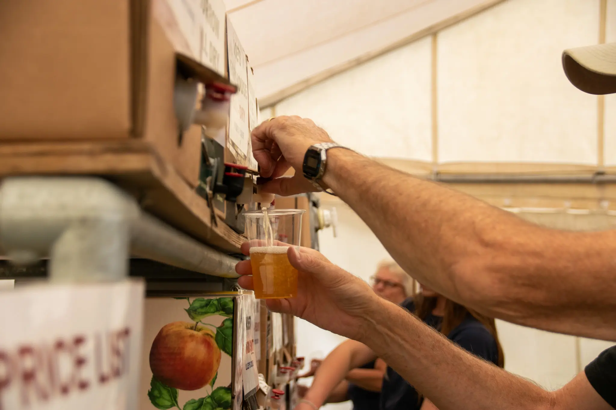 Person filling glass at beverage station