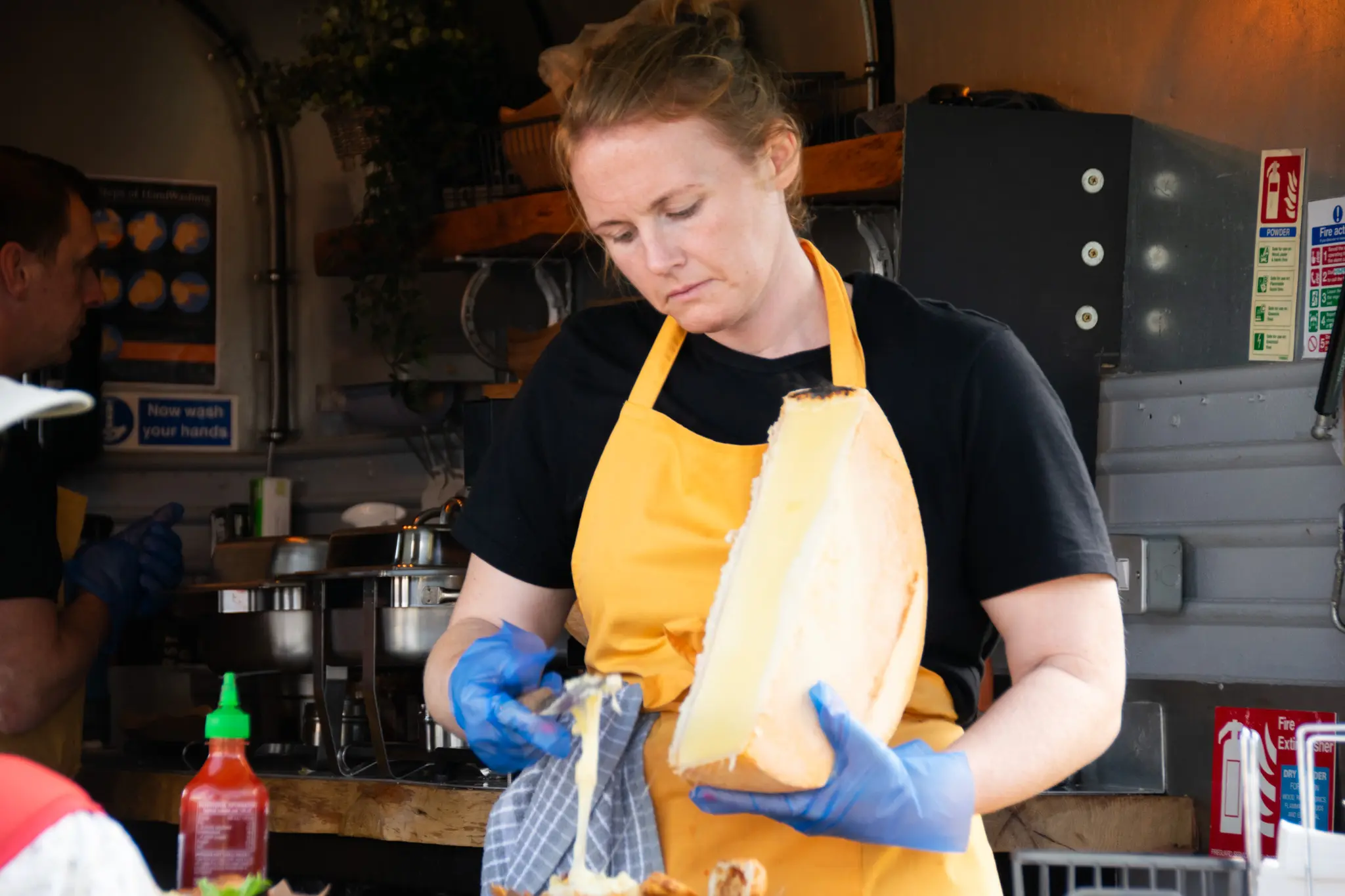 Chef using cheese wheel in kitchen