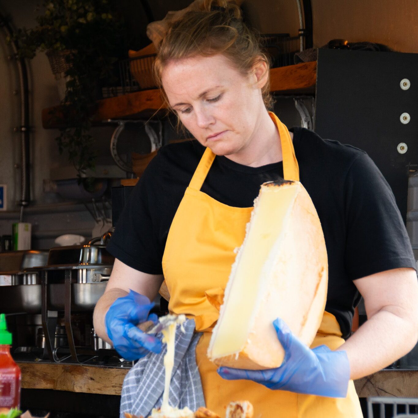 Chef using cheese wheel in kitchen